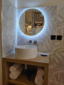 uma casa de banho com um lavatório e um espelho em LA BULLE ROMANTIQUE, Suite avec jacuzzi privatif 