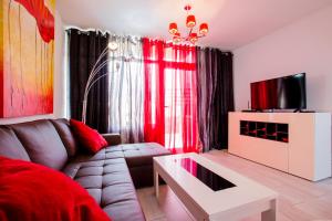 ein Wohnzimmer mit Sofa und Fernseher in der Unterkunft Bungalow Costa Adeje Cortijo 1-8 in Playa de las Americas