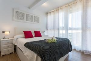 a bedroom with a large bed with red pillows at Apartments Vistas Mar Bahia in Cádiz