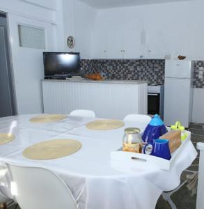 una mesa blanca con sillas blancas en la cocina en White Villa in Olive trees and Seaview to Panagia, en Almiropótamos