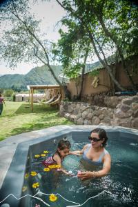 una donna e un bambino in piscina di Unuwasi Hotel & Villa a Calca