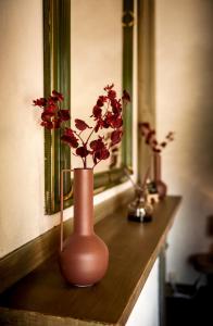 un jarrón con flores en él sentado en una mesa en B&B Pura Vista, en Zandhoven
