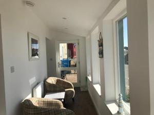 a living room with two chairs and a window at Lovely 3-Bed Cottage Portmahomack next to harbour in Portmahomack