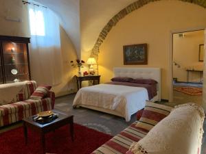 a hotel room with a bed and a couch at Appartamento Antica Acropoli in Centuripe