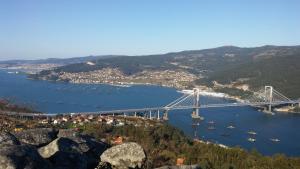 un puente sobre un río con barcos en el agua en Albergue A ROTONDA, en Redondela