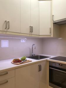 a kitchen with a sink and a plate of food on a counter at Apartament luster i obrazów in Warsaw