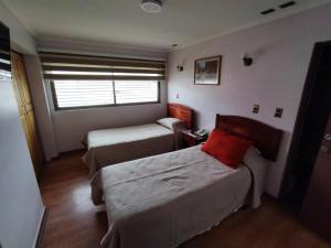 a small room with two beds and a window at HOTEL MILLARAY INN express in Angol