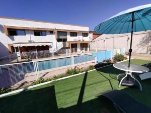 a patio with a table and an umbrella at HOTEL MILLARAY INN express in Angol