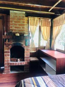 a living room with a brick fireplace in a bedroom at Hospedaje Puntzán in Baños