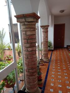 a row of brick pillars in a room with plants at Fernan Caballero in Carmona