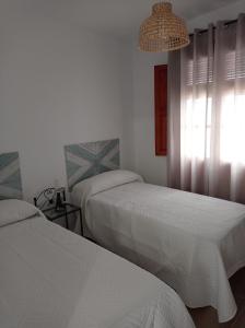 una camera d'albergo con due letti e una finestra di Fernan Caballero a Carmona