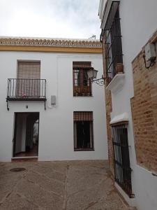 um edifício branco com duas janelas e uma varanda em Fernan Caballero em Carmona