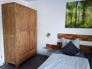 una camera da letto con un letto e un armadio in legno di Kleines Nest a Radebeul