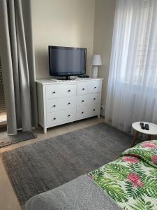 a bedroom with a tv on a white dresser at Zielone Studio in Giżycko