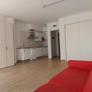 ein Wohnzimmer mit einem roten Sofa und einer Küche in der Unterkunft Villa Treccani Apartments in Malcesine