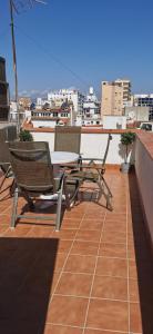 uma mesa e cadeiras no telhado de um edifício em Ático acogedor, céntrico y a 2 min de la playa. em Fuengirola
