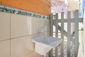 a bathroom with a white sink next to a staircase at BANGALOS FLORIANÓPOLIS in Florianópolis