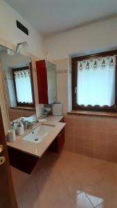 a bathroom with a sink and a mirror and two windows at Kalipè Dolomiti in Soffranco +45 photos
