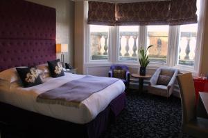 um quarto de hotel com uma cama grande e janelas em 24 Royal Terrace em Edimburgo