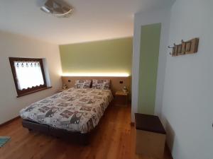 a bedroom with a large bed and a window at Kalipè Dolomiti in Soffranco