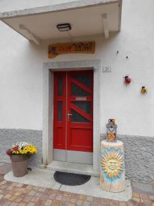 eine rote Tür an der Seite eines Gebäudes in der Unterkunft Kalipè Dolomiti in Soffranco