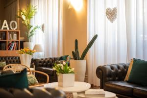 a living room with leather couches and plants at Hotel Tigullio in Lavagna