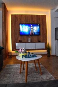 a living room with a table and a tv on a wall at Vuković Lux in Vrnjačka Banja