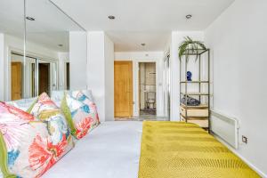 a bedroom with a bed with colorful pillows at Riverside 2- Bedroom Apartments in London +54 photos