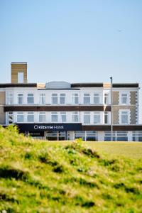 a large building in front of a green field at The Kilbirnie Hotel in Newquay