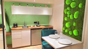 a kitchen with a table and a green wall at Suite Saint Lô Rouen (Centre Historique) in Rouen