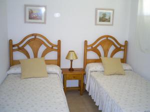 ein Schlafzimmer mit 2 Betten und einem Tisch mit einer Lampe in der Unterkunft Santa Pola beach 2 habitaciones in Santa Pola