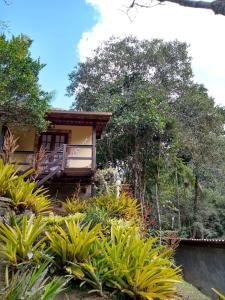 Casa con balcón y algunas plantas en OYO Pousada Luar da Serra Lumiar, en Lumiar