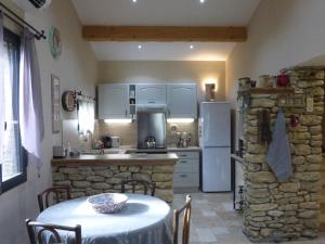 cocina con mesa y chimenea de piedra en holiday home, Bédarrides, en Bédarrides