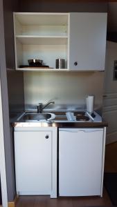 a kitchen with white cabinets and a sink at Au Troubadour in Hellemmes-Lille