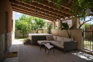 a patio with a couch and a hot tub at Apartmani M&C in Fažana