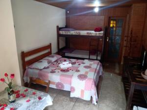 una habitación con 2 camas y una mesa con flores. en OYO Pousada Luar da Serra Lumiar, en Lumiar