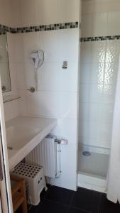 a white bathroom with a shower and a sink at Au Troubadour in Hellemmes-Lille