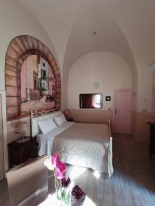1 dormitorio con cama blanca y ventana abovedada en Dormire nel Borgo, en Bovino