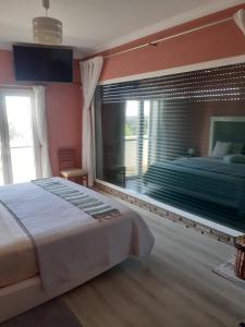 a bedroom with a large bed and a large window at Alojamento local Patudos, Suite com terraço privado in Tavira