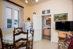 a living room with a table and a refrigerator at Christina's House in Argostoli