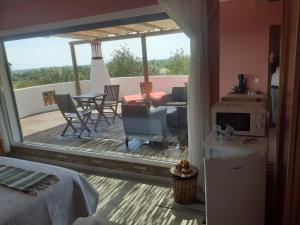 1 dormitorio con balcón con mesa y sillas en Alojamento local Patudos, Suite com terraço privado, en Tavira