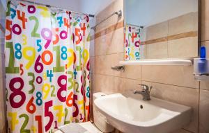 a bathroom with a sink and a shower curtain at Christina's House in Argostoli +6 photos