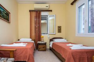 a room with two beds and a window at Christina's House in Argostoli
