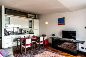 a kitchen with a table and chairs and a kitchen with white cabinets at Casa Vistabella in Salò +15 photos