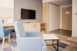 ein Wohnzimmer mit 2 Stühlen und einem TV in der Unterkunft Magnus Resort in Szczyrk