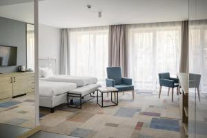 Habitación de hotel con cama, sillas y TV en Magnus Resort en Szczyrk