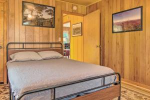 a bedroom with a bed in a room with wooden walls at Peaceful Spruce Pine Cabin on 8 Acres with 2 Decks! in Spruce Pine
