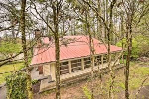 ein Haus mit rotem Dach im Wald in der Unterkunft Cozy Wooded Retreat 2 Mi to Dtwn Brevard! in Brevard