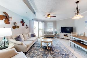 a living room with a couch and a tv at Dunes of Seagrove A104 in Santa Rosa Beach
