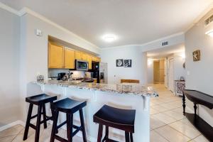 a kitchen with a counter and stools in a room at Dunes of Seagrove A104 in Santa Rosa Beach